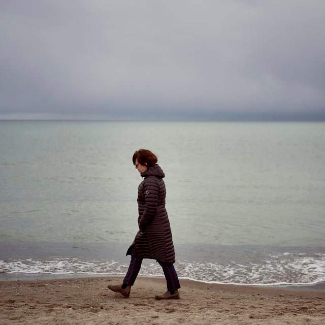 Donna che passeggia in riva al mare